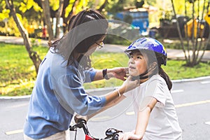 Mother teaching her daughter to ride bicycle in park. Family outdoor on bike ride