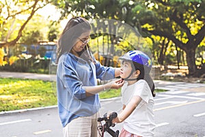 Mother teaching her daughter to ride bicycle in park. Family outdoor on bike ride