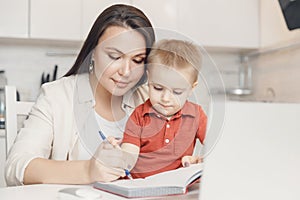 Mother teaching her kid son how to write pen. concept Online learning quarantine