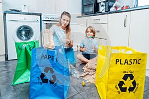 Mother is teaching kid how to recycle help the boy aware environmental importance - mom educates son sort garbage into