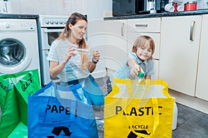 Mother is teaching kid how to recycle help the boy aware environmental importance - mom educates son sort garbage into