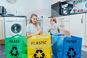 Mother is teaching kid how to recycle help the boy aware environmental importance - mom educates son sort garbage into