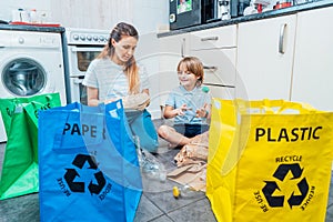 Mother is teaching kid how to recycle help the boy aware environmental importance - mom educates son sort garbage into different