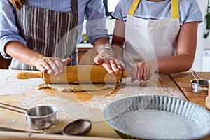 Mother making apple pie with children at home kitchen