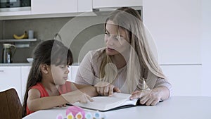 Mother teaching little daughter to read