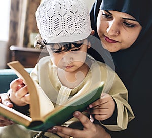 Mother teaching son to read Quran