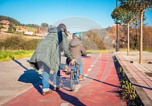 Mother teaching son to ride a bike in cycleway