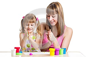 Mother teeaching daughter to use colorful play clay