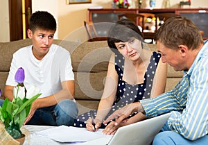 Mother and teen son with bank employee at home