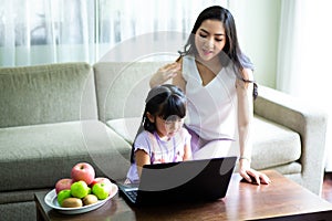 Mother And Teenage Daughter Looking At Laptop Together