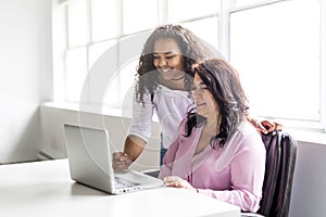 Mother And Teenage Daughter Looking At Laptop Together