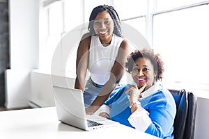 Mother And Teenage Daughter Looking At Laptop Together