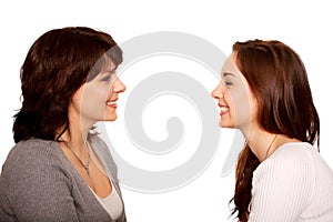 Mother and teenage daughter talking and laughing together.