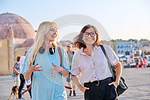 Mother and teenage daughter are walking together in the city
