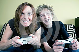 Mother and teenage son play video game together