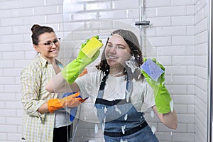 Mother and teenager daughter cleaning together in bathroom