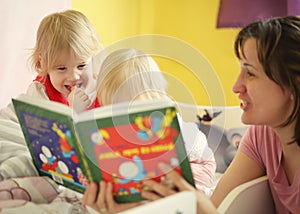 Mother tell tale in bed to her children photo