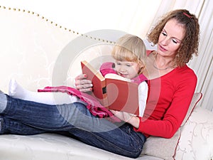 Mother tell tale from book in bed to her child