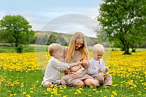 Mother and Three Children Playing in Flower Meadow