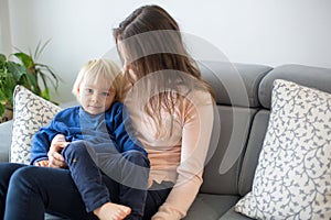 Mother, tickling her little toddler boy, child giggling at home