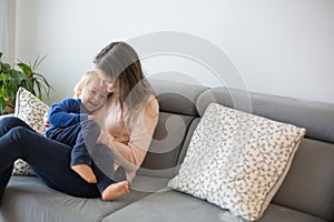 Mother, tickling her little toddler boy, child giggling at home