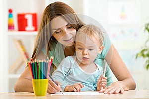 Mother and toddler child draw and paint together