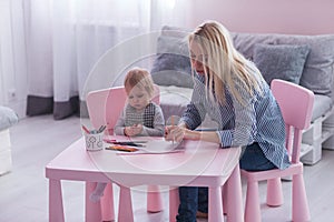 Mother and toddler child drawing and painting together