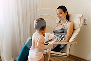 Mother and toddler reading books at home. Bonding quality time together