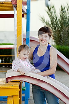 Mother with toddler on slide playground