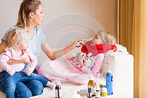 Mother treating her child`s sore throat