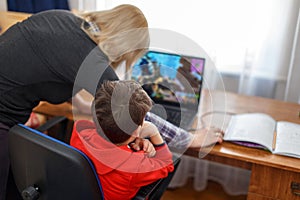 Mother turning off computer for computer addicted little gamer kid photo