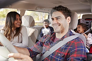 Mother turns around to her children on the back seat of car