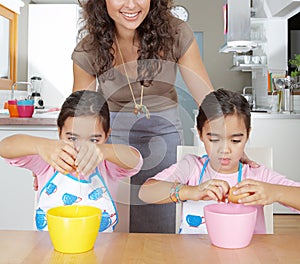 Mother and Twins Beating Eggs in Kitchen