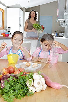 Mother and Twins Beating Eggs in Kitchen