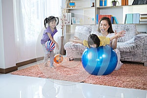 A mother, two Asian daughters, happily playing at home, mother and daughter smiles