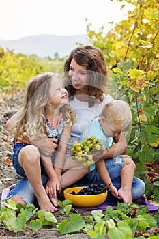 Mother with two babies boy and girl in vineyard