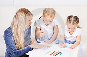 Mother with two beautiful daughters are drawing. Family, motherhood concept.
