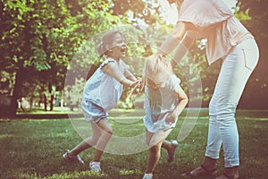 Mother with two child in meadow. Mother holding hands with girl