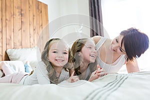 Mother and two children in the bedroom on the bed