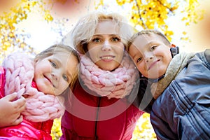 Mother and two children looking down in autumn