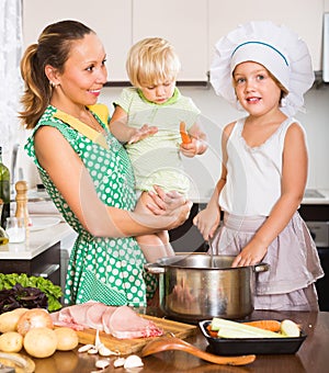 Mother with two daughters cooking