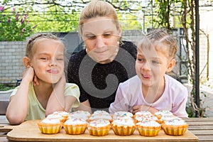 Mother and two daughters salivate looking freshly Easter cupcakes