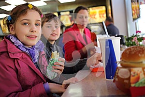 Mother with two kids have snack in fast food
