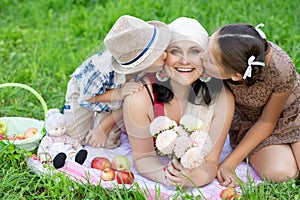 Mother with two kids having picnic outdoors