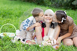 Mother with two kids having picnic outdoors