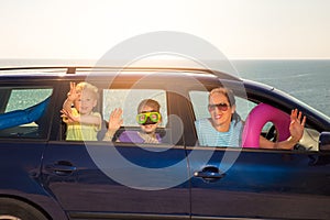 Mother with two kids travel by car on sea vacation