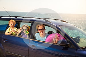 Mother with two kids travel by car on sea vacation