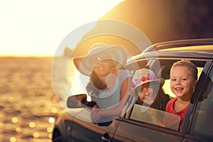 Mother with two kids travel by car on summer vacation, sunset