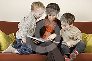 Mother And Two Sons Reading A Book 1