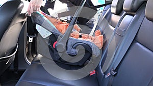 Mother unfasten safety belts on child in car seat. 4K